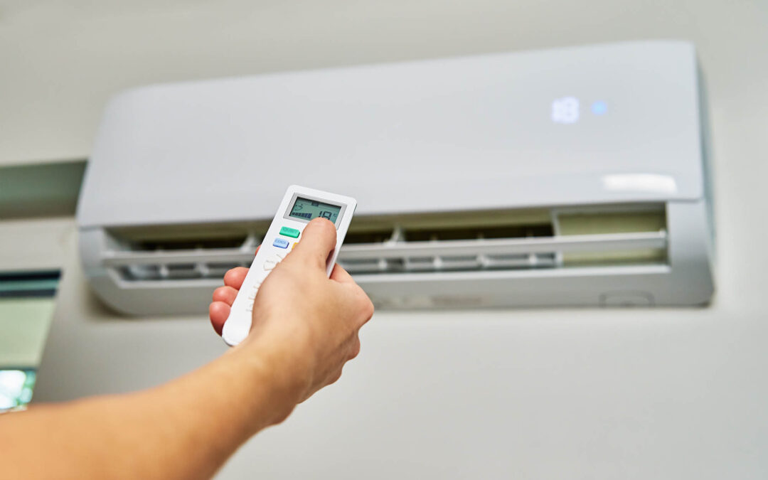 Hand adjusting temperature on air conditioner